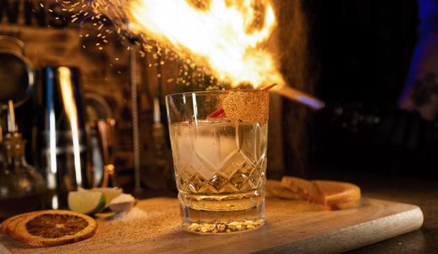 Cocktail with blowtorch and flame