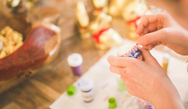 An image of someone using jewels to decorate an egg. 